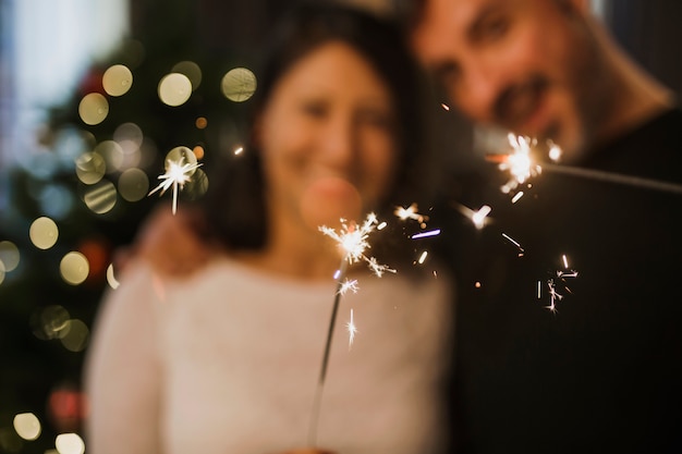 Free photo cheerful senior couple holding fireworks