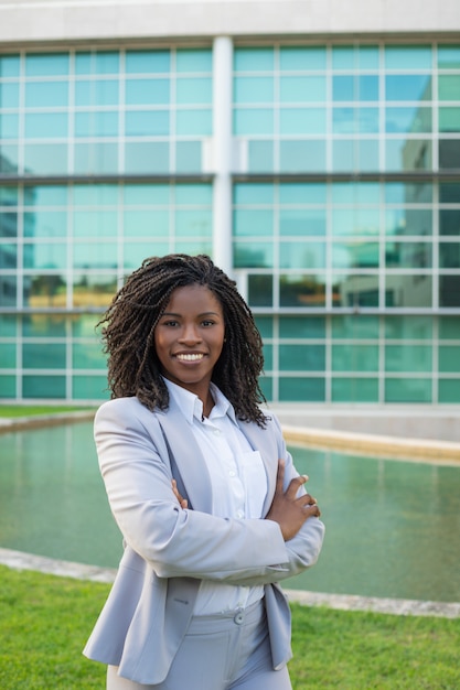 Cheerful smiling female professional posing near office