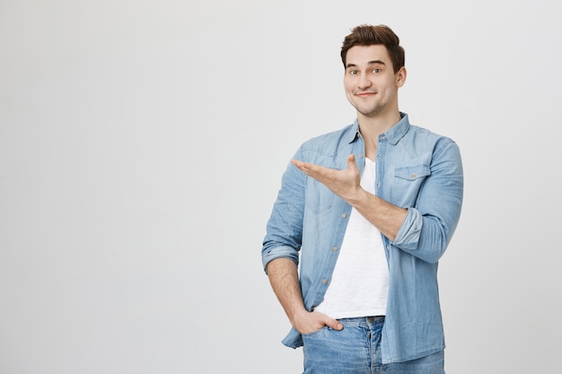 Cheerful smiling guy introduce banner, pointing hand left