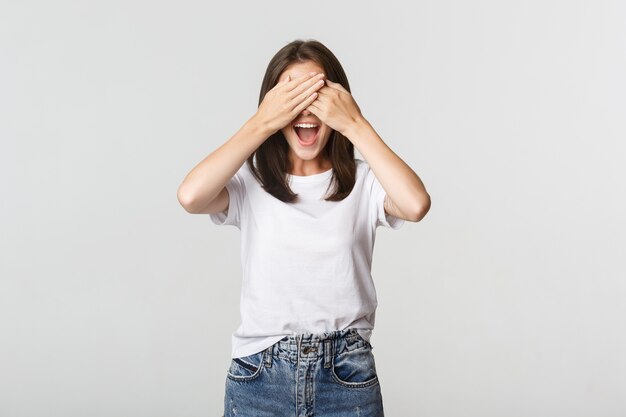 Cheerful smiling woman shut eyes and expect surprise.