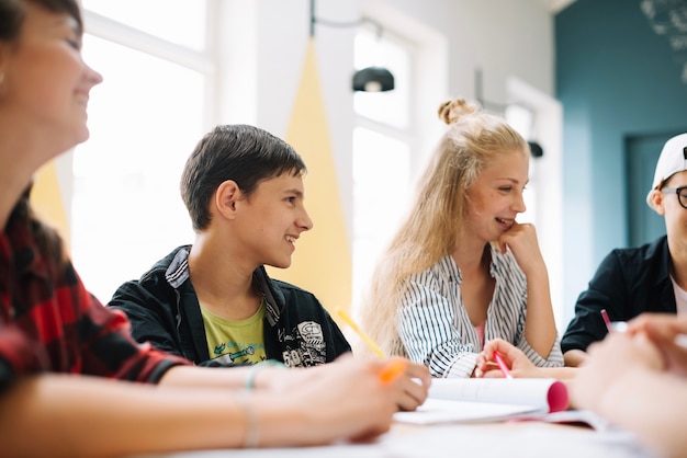 Cheerful students having talk in classroom