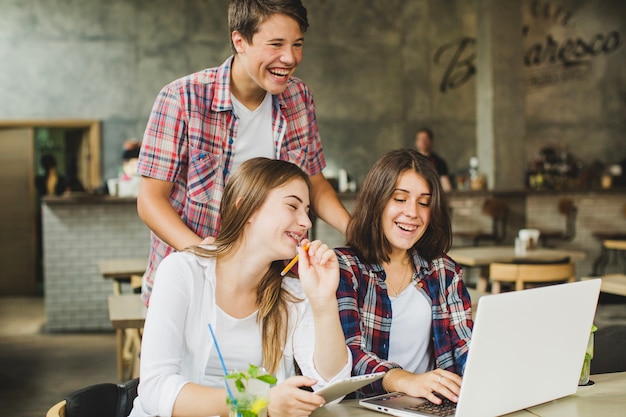 Free photo cheerful students posing with laptop