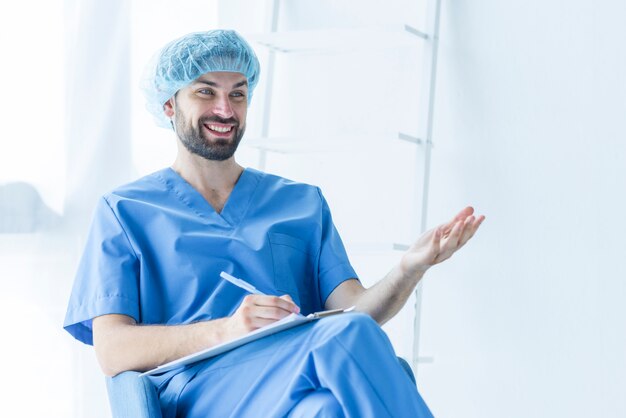 Cheerful surgeon with clipboard