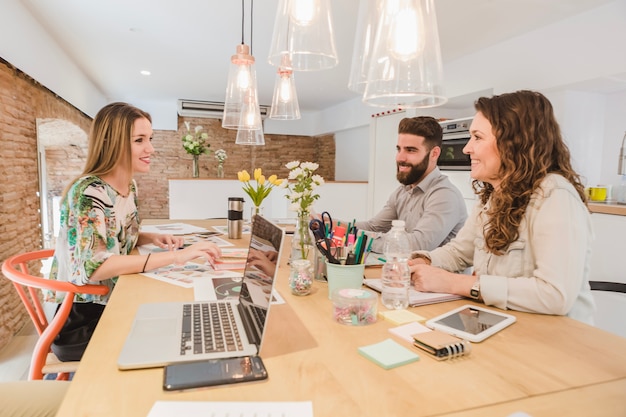 Free photo cheerful team working with papers and gadgets