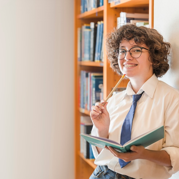 Cheerful teen girl in library