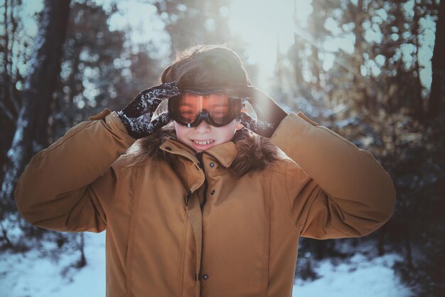 Free photo cheerful teenager is enjoying winter walk at forest at bright, sunny day.