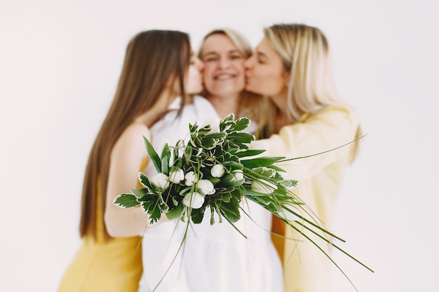 Cheerful two generation blonde women isolated on white background. Flowers bouquet.