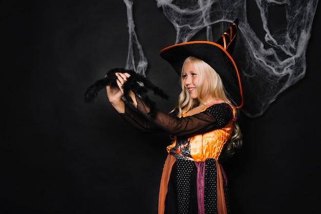 Cheerful witch with fluffy toy spider