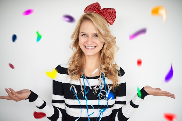 Free photo cheerful woman catching confetti pieces