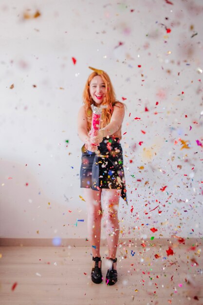 Cheerful woman celebrating with party popper