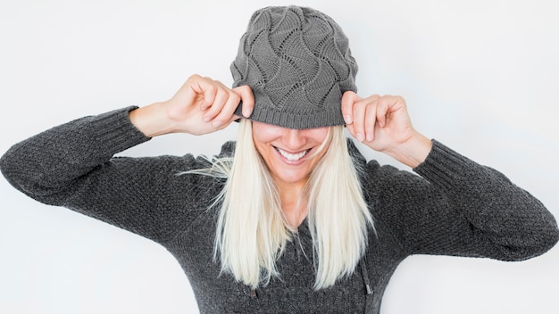 Free Photo cheerful woman hiding face behind hat