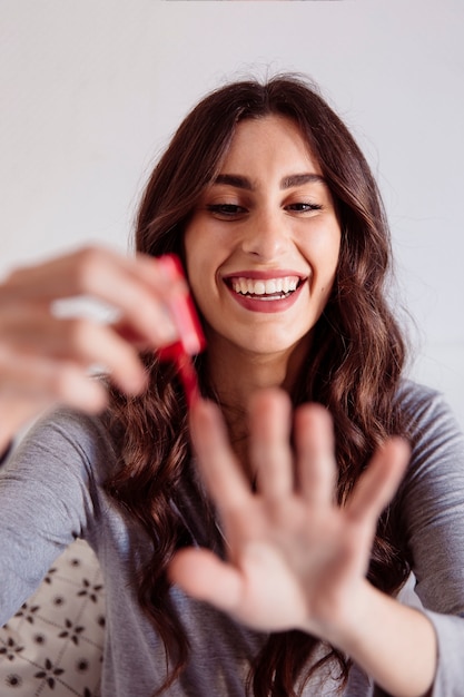 Cheerful woman painting nails