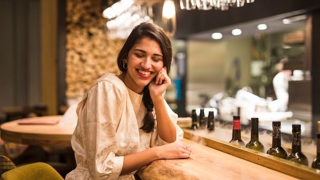 Cheerful woman sitting at bar counter