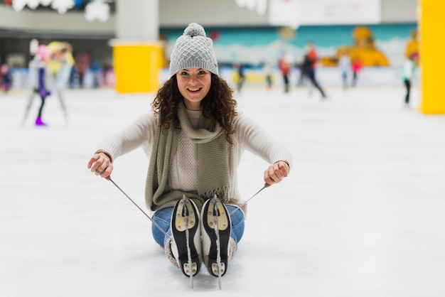 Free photo cheerful woman sitting on ice