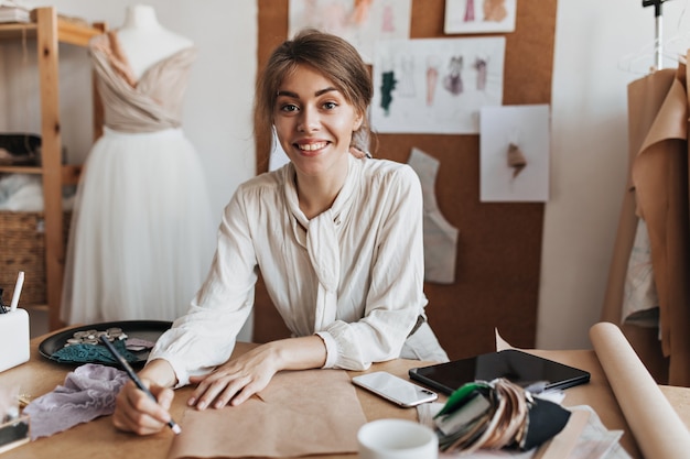 Cheerful woman in stylish blouse drawing sketch