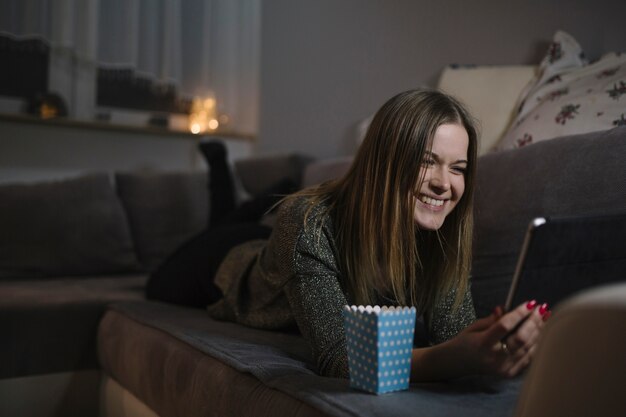 Cheerful woman watching film on tablet