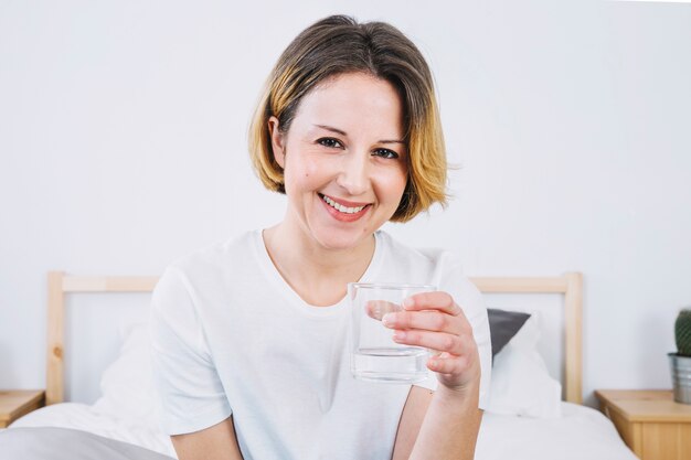 Cheerful woman with glass of water