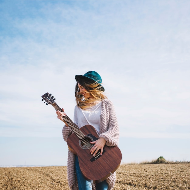 Free Photo cheerful woman with guitar in countryside