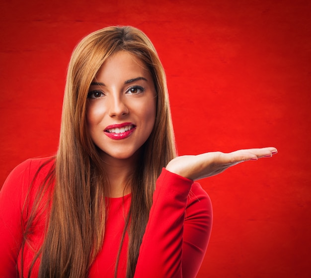 Free photo cheerful woman with open hand palm on red background