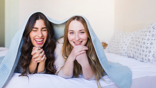 Free photo cheerful women under blanket