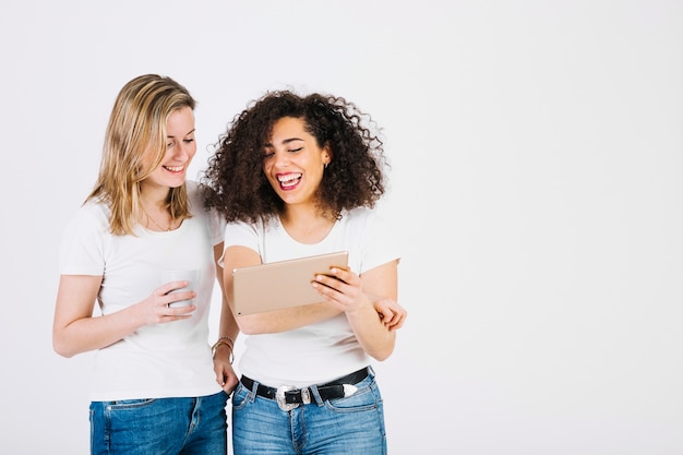 Cheerful women browsing tablet together