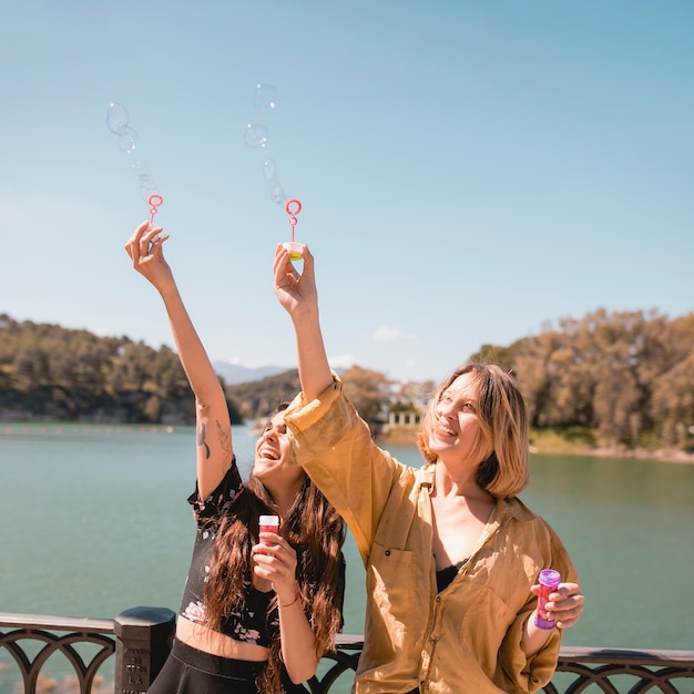 Cheerful women catching bubbles