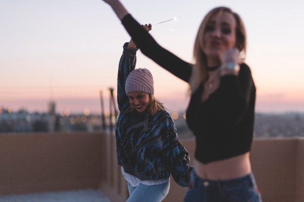 Free photo cheerful women dancing with sparklers