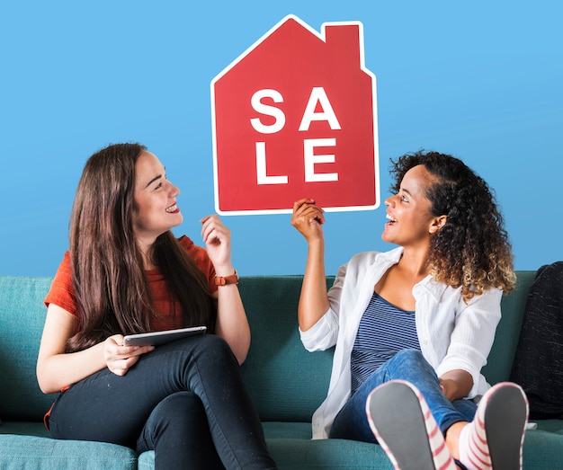 Free Photo cheerful women holding a house sales icon