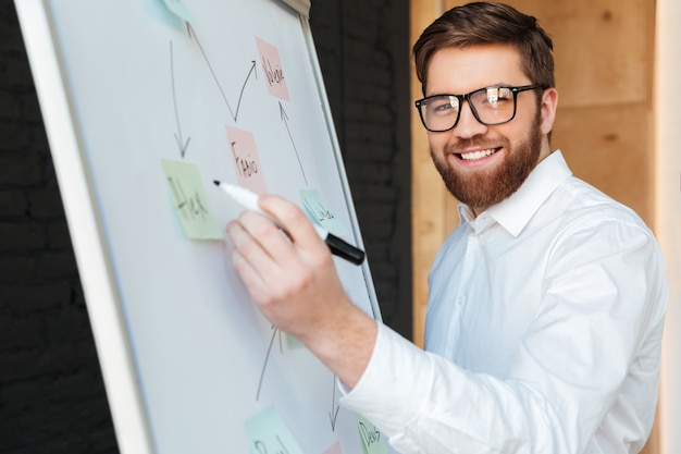 Free photo cheerful young businessman write something