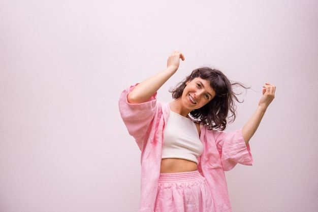 Free Photo cheerful young caucasian brunette in top shirt and pants is actively moving posing on white background people emotions lifestyle and fashion concept