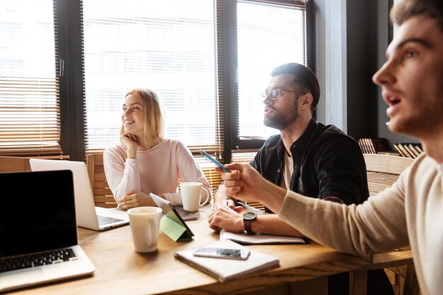 Cheerful young colleagues sitting in office