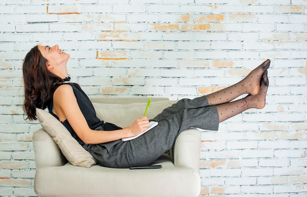 Cheerful young girl lying on the armchair and smiling High quality photo