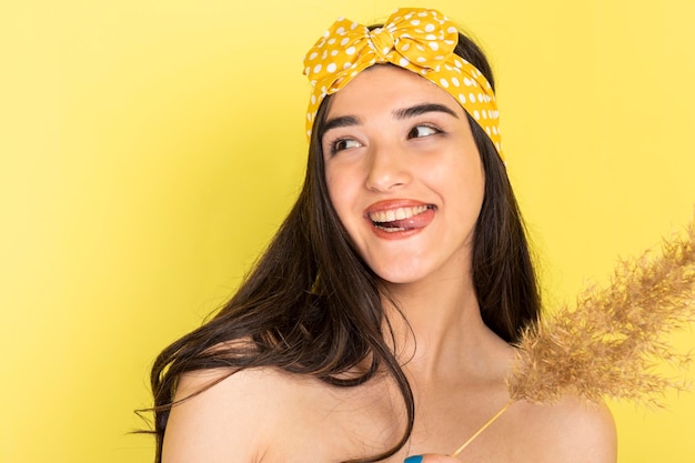 Free photo cheerful young girls standing on yellow background and laughing