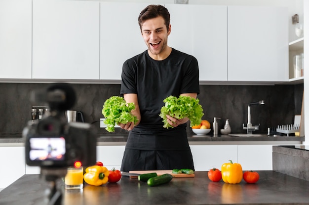 Free photo cheerful young man filming his video blog episode