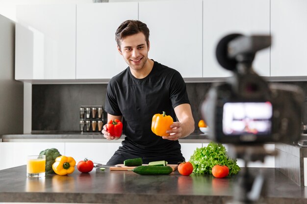 Free photo cheerful young man filming his video blog