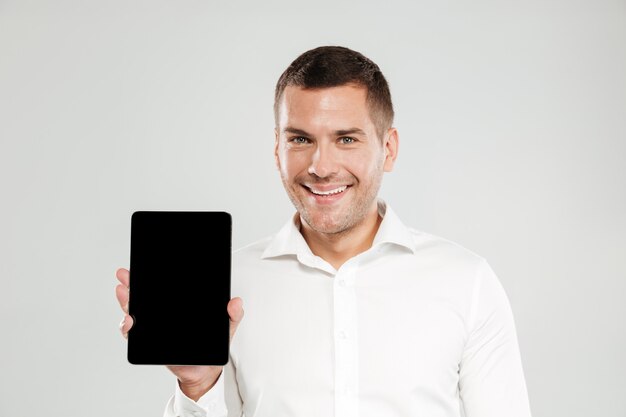 Cheerful young man showing display of tablet computer.