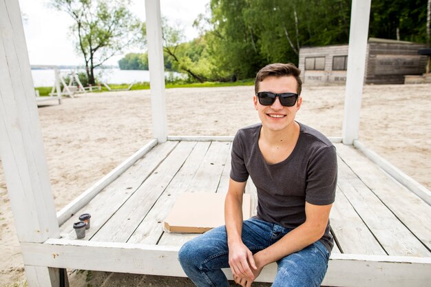 Cheerful young man sitting on beach