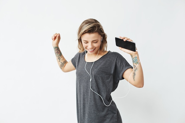 Free Photo cheerful young pretty girl smiling listening music in headphones dancing .