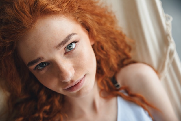 Cheerful young redhead lady lies on hammock