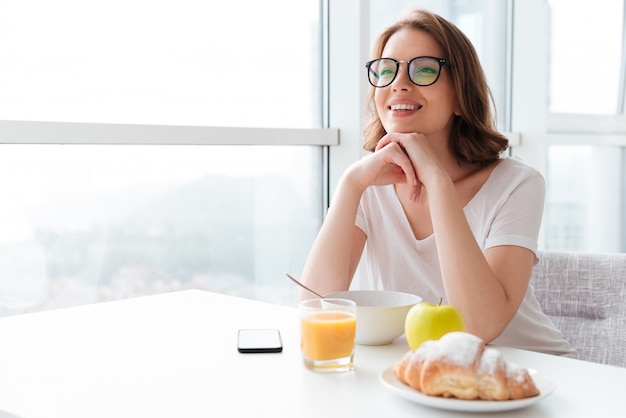 Free photo cheerful young woman eating corn flakes