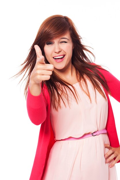 Cheerful young woman pointing at camera