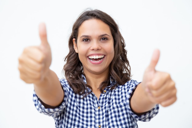 Cheerful young woman showing thumbs up