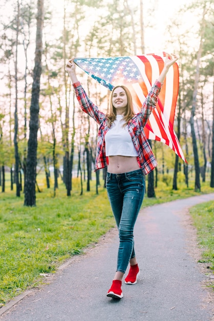 Cheerful young woman with flag of USA