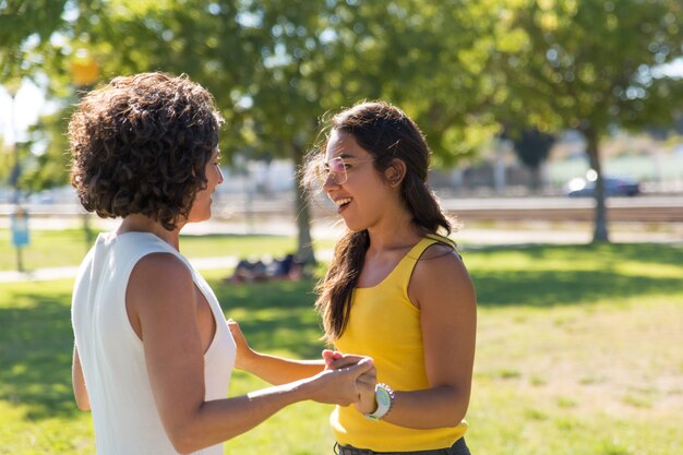 Cheerful young women talking in park