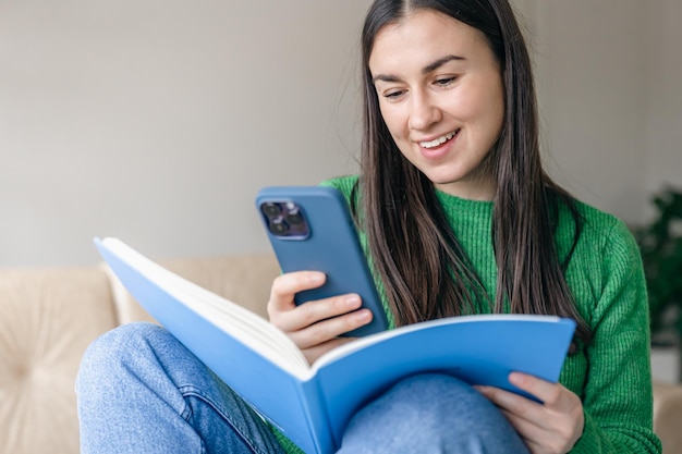 Free photo cheerful young women with a smartphone and a notepad in their hands