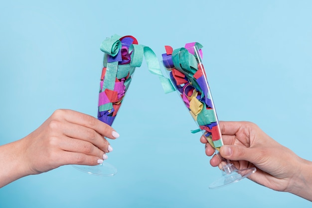 Cheers with glasses with confetti