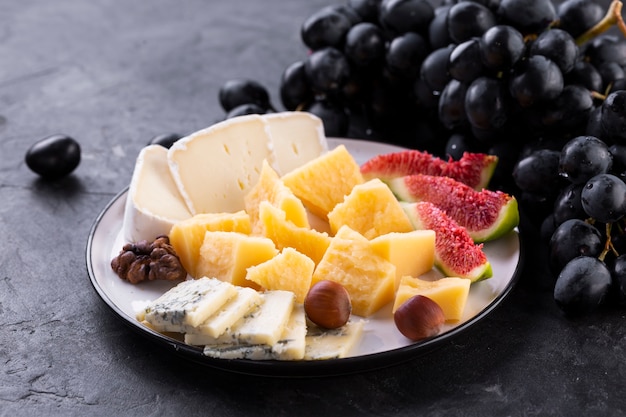 Cheese assortment with black grapes and nuts