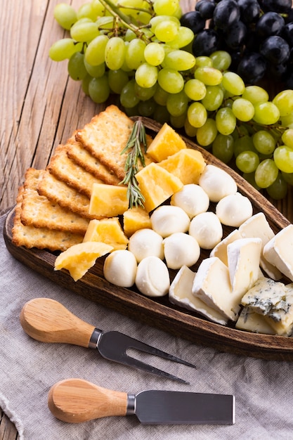 Free Photo cheese assortment with black and white grapes