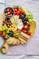 Free photo cheese board with fresh fruits and crackers