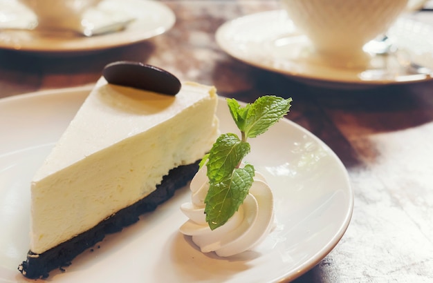 Free photo cheese cake with cup of hot coffee in coffee shop